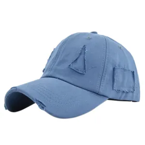 Close-up of vintage washed blue cotton baseball cap featuring distressed ripped hole details