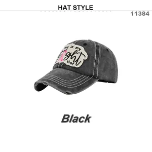 Detalle de gorra de béisbol lavada con bordado de lazo rosa y parche de This is my Fight Hat