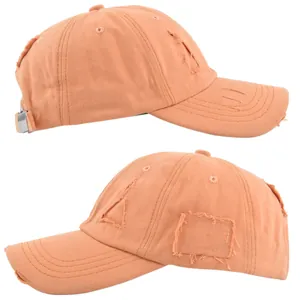 Detail view of distressed orange cotton baseball cap with frayed holes and metal buckle