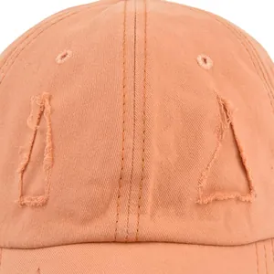 Distressed vintage cotton baseball cap featuring frayed holes and washed orange finish