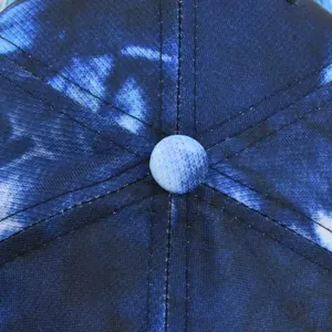 Detailed top view of the tie-dye gradient baseball cap with reinforced stitching and button