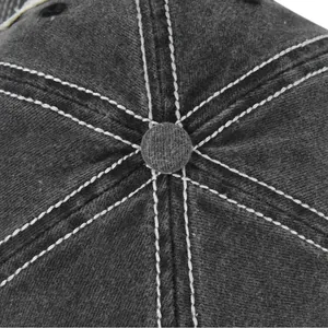 Primer plano de la corona de gorra gris con costuras blancas en contraste y botón superior