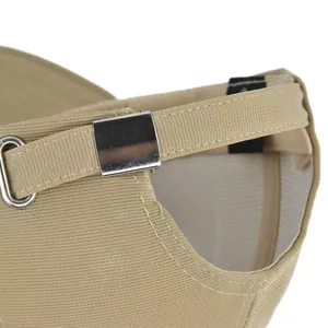 Détail d'une casquette en coton kaki montrant la boucle argentée et les coutures fines