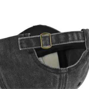 Detailed macro of the adjustable bronze buckle on a vintage washed grey baseball cap