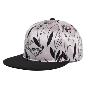 Detail of pink satin baseball cap with floral print and black flat brim and top button