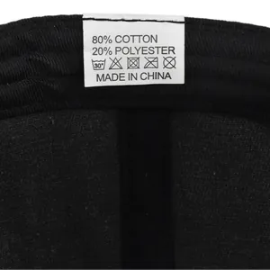 Detail showing white care label with 80% cotton composition on a black baseball cap