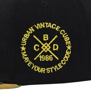 Gros plan sur la broderie jaune Urban Vintage sur la casquette de baseball noire