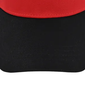 Macro shot of two-tone red and black baseball cap showing reinforced stitching and cotton texture