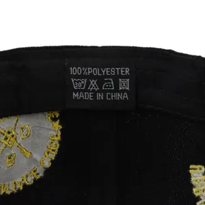 Gros plan de l'étiquette d'entretien en polyester et broderie jaune sur casquette noire