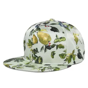 Detailed 45-degree view of mint green silk-like baseball cap with botanical flower and bird print