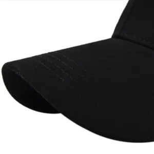 Détail des coutures renforcées sur la visière d'une casquette en maille noire pour queue