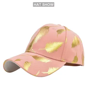 Detail of pink baseball cap with metallic gold feather patterns and curved brim