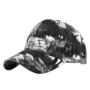 Close-up of black graffiti prints including EXP and KICK letters on a white baseball cap