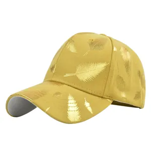 Detailed view of metallic gold feather print on ginger yellow baseball cap fabric