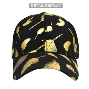 Detail of baseball cap featuring metallic gold feather prints on black fabric texture