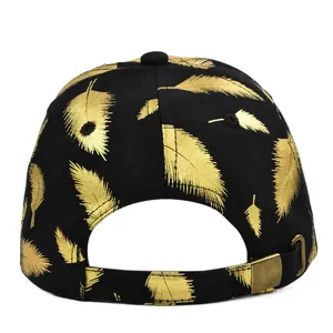 Detail of adjustable strap with vintage metal buckle and gold feather print on black cap