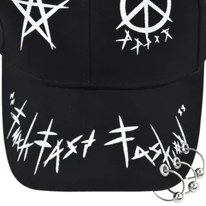 Vue détaillée d'une casquette punk noire avec des anneaux métalliques sur la visière