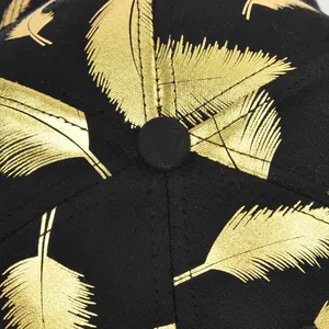 Macro shot of gold feather print on black twill fabric of the baseball cap top