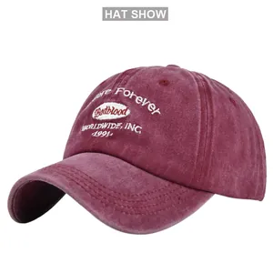 Close-up of vintage washed burgundy cotton baseball cap with white embroidery detail