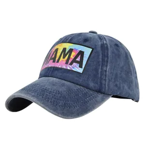 Détail de la casquette en denim bleu marine avec patch MAMA tie-dye et broderie