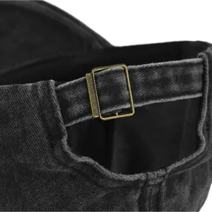 Detail view of the vintage washed denim baseball cap with adjustable bronze metal buckle