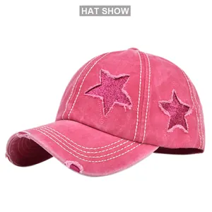 Dettaglio della stella glitter rosa e cuciture bianche a contrasto su cappello denim