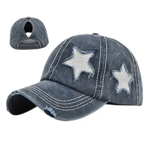 Dettaglio cappello in denim lavato con foro per coda di cavallo e stella di paillettes