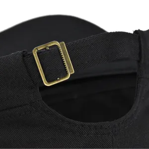 Detail of adjustable vintage brass buckle on black cotton twill military style cap