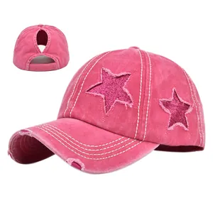 Dettaglio delle stelle con paillettes rosa e visiera invecchiata sul cappellino con coda