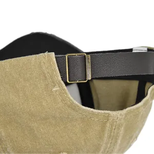 Detailed close-up of khaki corduroy fabric and brown leather strap with metal buckle