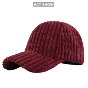 Detail of deep red corduroy baseball cap showing textured ribbed fabric and curved brim