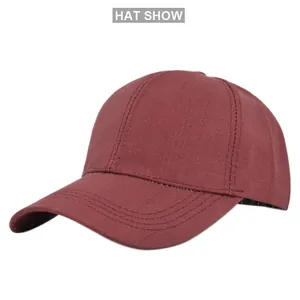 Close-up of wine red baseball cap showing reinforced stitching on the brim and cotton texture