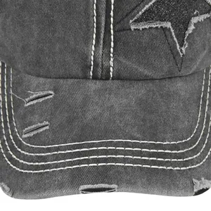 Dettaglio macro di un cappello da baseball in denim grigio con stella e bordi usurati