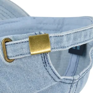 Detail of adjustable brass buckle and denim strap on light blue baseball cap