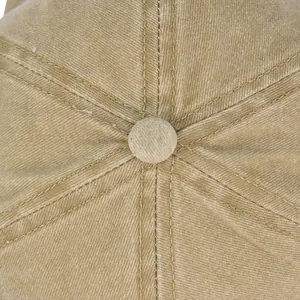 Close-up of khaki cotton baseball cap top button and detailed six-panel stitching texture