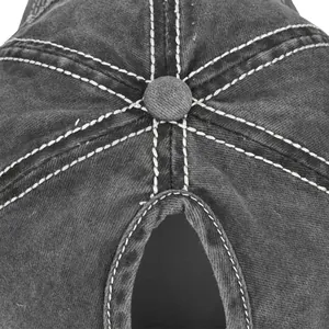 Dettaglio cappello da baseball in denim grigio con cuciture bianche e foro per coda di cavallo
