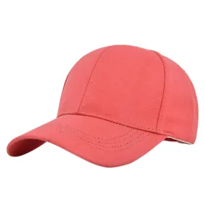 Detail of coral red cotton baseball cap showing textured fabric and reinforced stitching