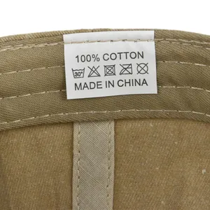 Detail view of cotton baseball cap inner wash label showing 100% cotton fabric and care icons