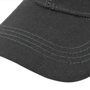 Close-up of black baseball cap brim with durable twill texture and four reinforced seams