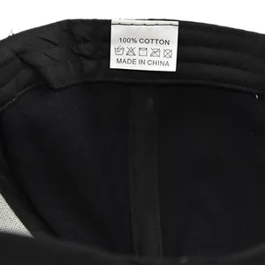 Détail de l'étiquette 100% coton et des coutures intérieures sur casquette noire