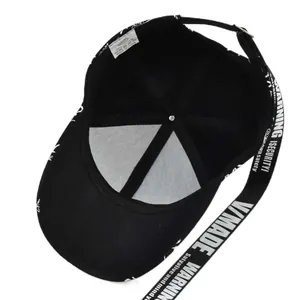 Detail of 100% cotton baseball cap showing white V/MADE printing on the brim and strap