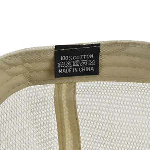 Detailed macro view of internal 100% cotton tag and mesh lining on washed baseball cap