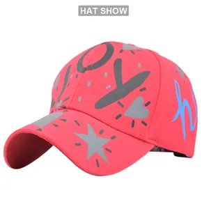 Detail of red graffiti baseball cap showing JOY text and star patterns from a side angle