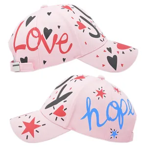 Detail view of pink cotton baseball cap featuring graffiti Love and Hope prints