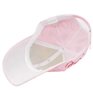 Detail of pink cotton baseball cap showing interior wash label and metal buckle strap