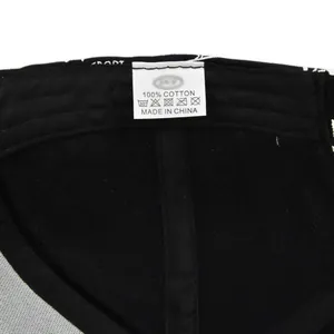 Detailed macro view of the 100% cotton washing label and mesh fabric on the black cap