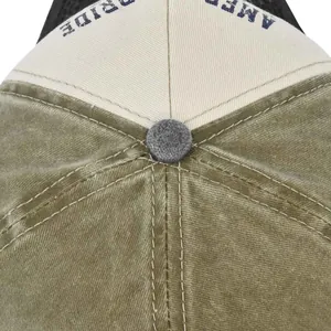 Detailed macro view of olive canvas stitching and grey button on the mesh trucker cap