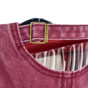 Detalle de la hebilla de metal ajustable y correa de algodón granate en la gorra