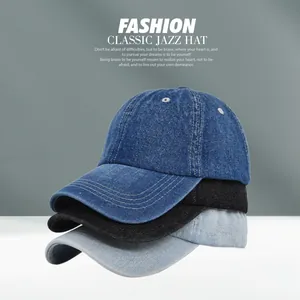 Detail of stacked denim baseball caps in dark blue, black and light blue with contrast stitching