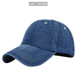 Detailed view of dark blue denim baseball cap with white contrast stitching and eyelets
